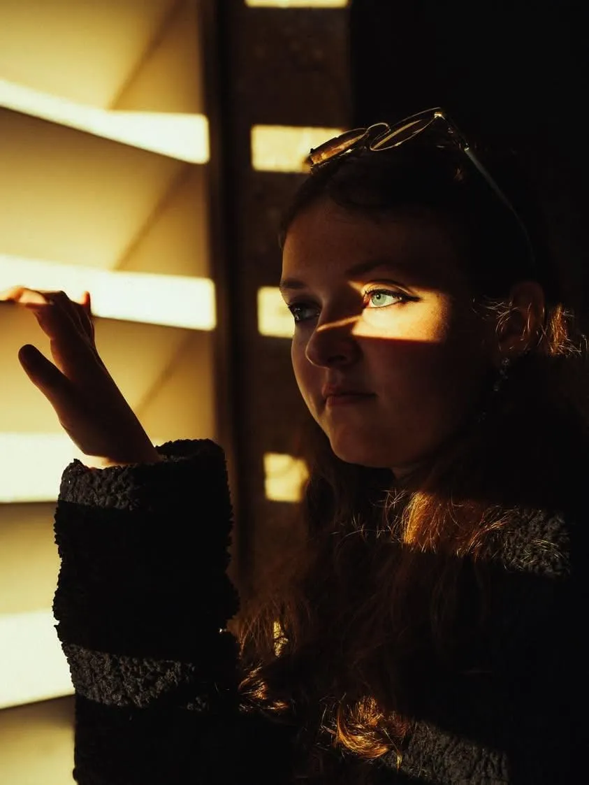 Portrait subject in dramatic window-blind shadow light