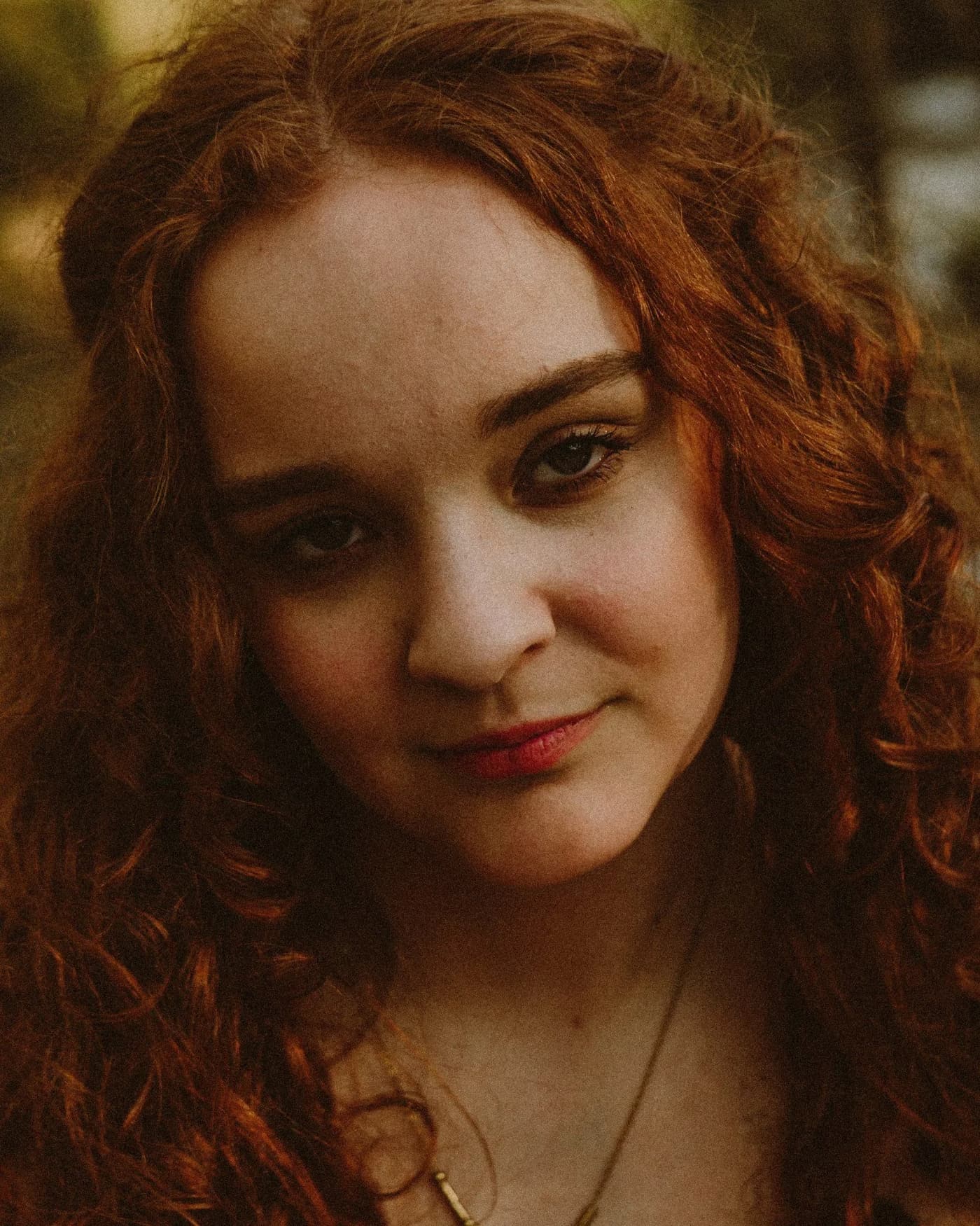 Portrait of a young woman with curly red hair