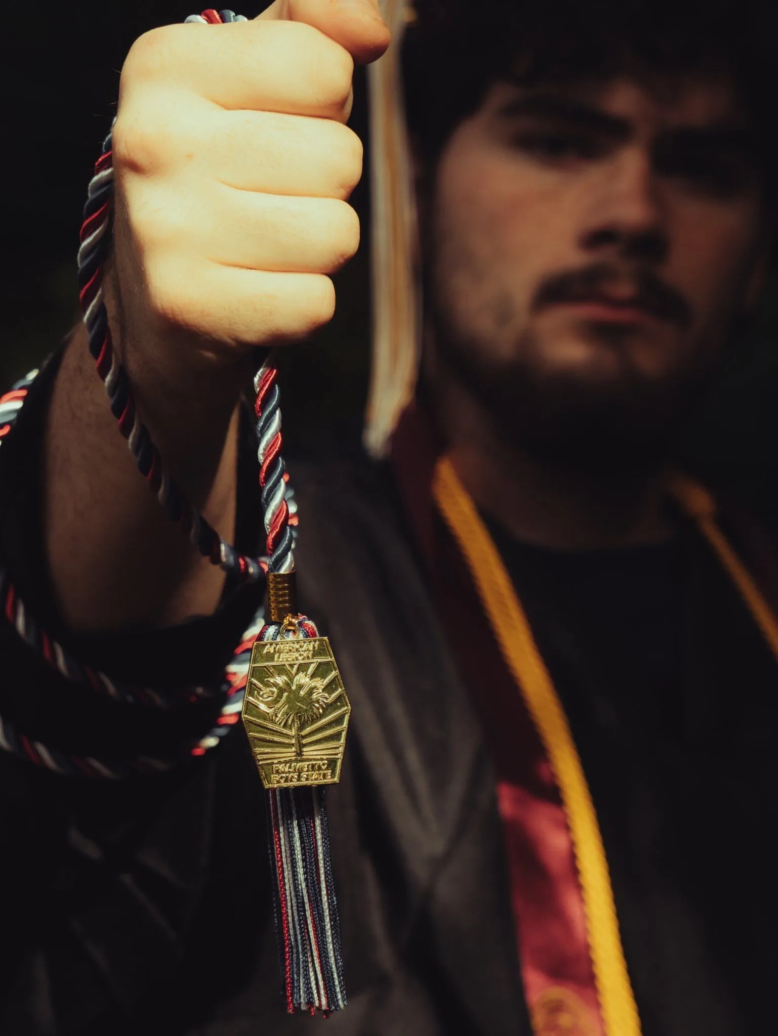 Graduate in cap and gown holding a medal